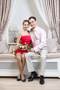 Happy young couple posing in luxury interior