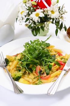 pasta with vegetables and salad close up