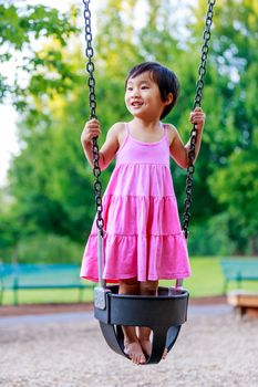 Adorable girl plays on the swing