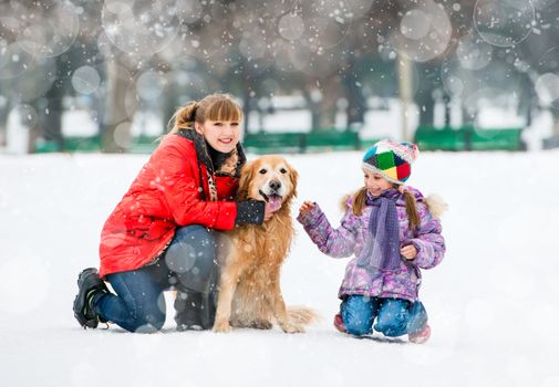 Happy family on a winter walk with the dog breed golden retriever