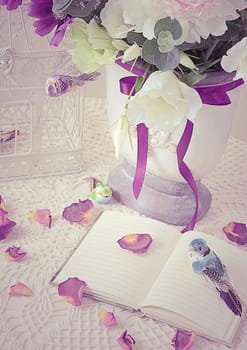 The book on a table with rose-petals