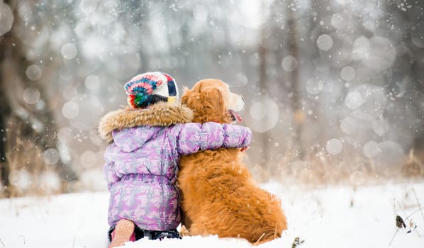 little girl hugging dog and looks forward