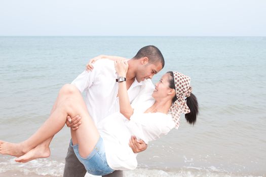 african man and asian woman lover on the beach