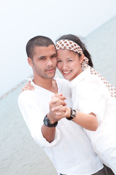 african man and asian woman lover on the beach