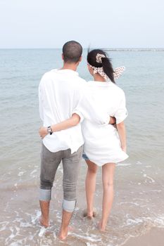 african man and asian woman lover on the beach