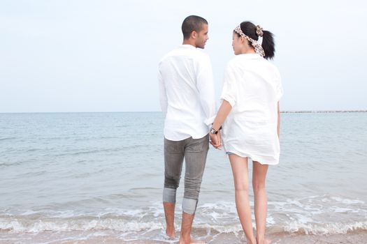 african man and asian woman lover on the beach