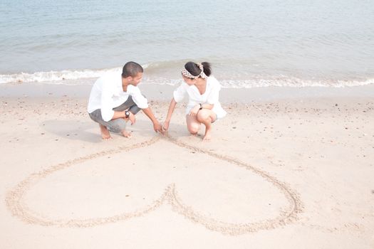 african man and asian woman lover on the beach