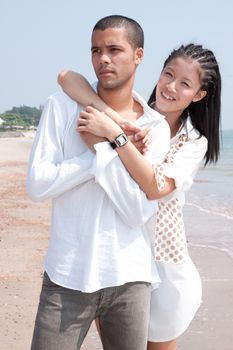 african man and asian woman lover on the beach