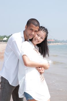 african man and asian woman lover on the beach