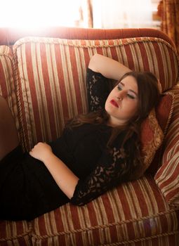 Brunette woman lying on classic couch