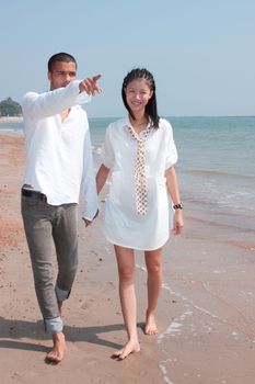 african man and asian woman lover on the beach