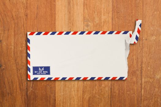 Envelope by air mail isolated on wood