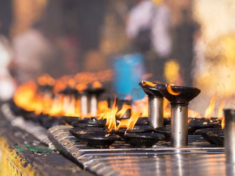 Burning oil lamps at the Shwedagon Pagoda in Yangon, the capital of Republic of the Union of Myanmar. Shallow depth of field.