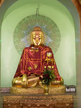 Buddha image with a purple robe and an LED halo around its head, during evening at the Shwedagon Pagoda in Yangon, the capital of Republic of the Union of Myanmar.