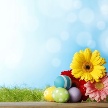 Colourful traditional Easter eggs arranged with colourful Gerbera daisies