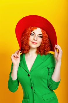 Attractive red-haired girl in red shady hat shot closeup