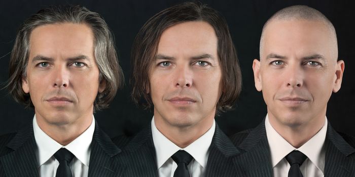 Close-up of a man in a business suit with three different hairstyles: bald, colored brown and greying.