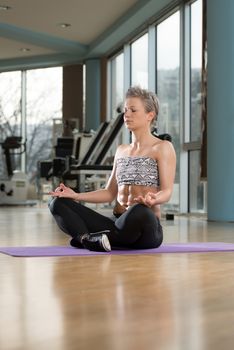 Woman Meditating In A Health Club Doing Yoga