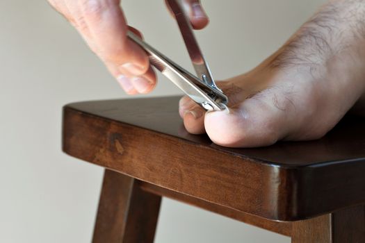 Male foot closeup as he clips his large toe nail.