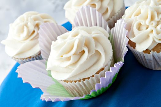 Close up of decadent gourmet cupcakes with vanilla frosting. 