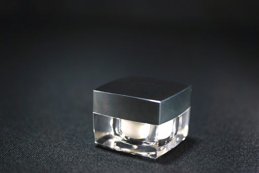 cube acrylic cream jar, on black scene,shallow focus