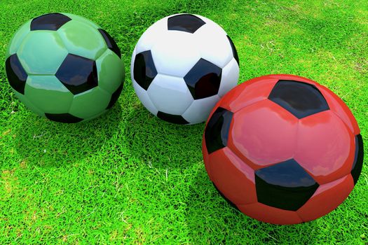 Green, white and red soccer balls on grass