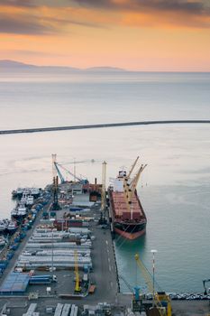 View of the busy harbor of Salerno, Italy, at sunrise with ships and containers on the dock