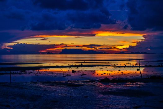 The sun sets over beach with beautiful reflection