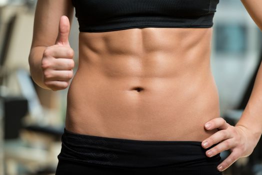 Beautiful Sporty Woman Showing Thumbs Up And Her Ab