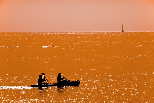 A young couple kayaking at dusk