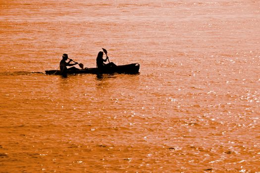 A young couple kayaking at dusk