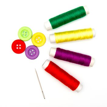 sewing buttons and needle with thread isolated on white