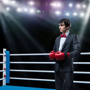 image of a businessman with boxing gloves in the ring, the competition in the business