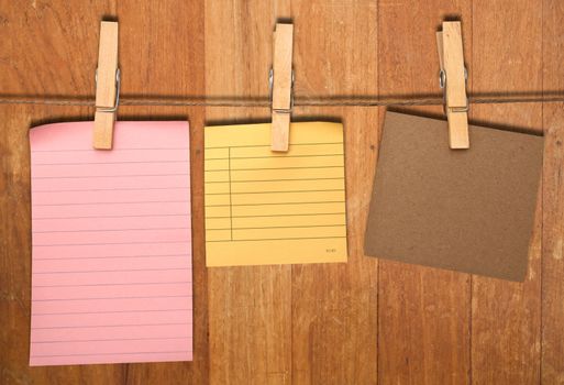 close up of a notes and a clothes pegs on wood wall