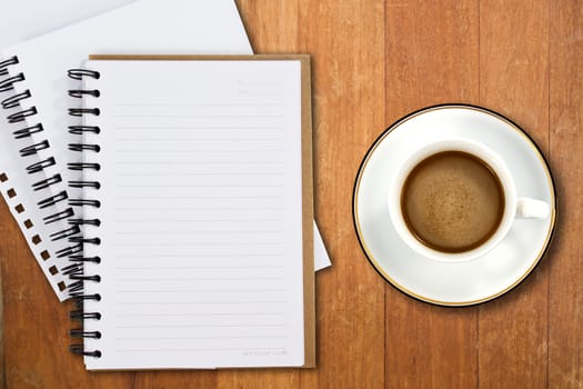 White cup of coffee and notebooks on wood table