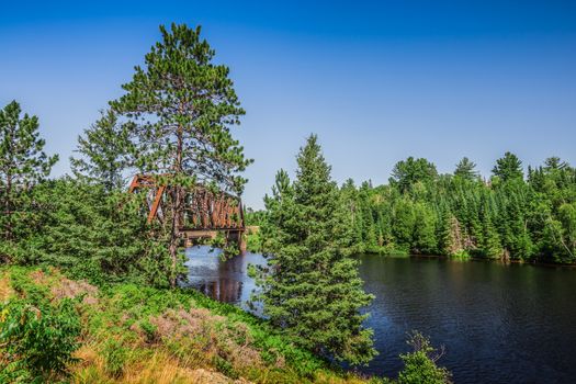 An amazing landcape of the nature containing a lake and a beautiful blue sky. The wild nature of Ontario, Canada.