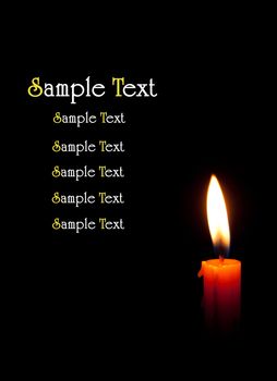 single burning candle isolated in front of black background