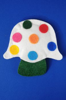 Cloth Multicolored Magic Mushroom on a Colored Background