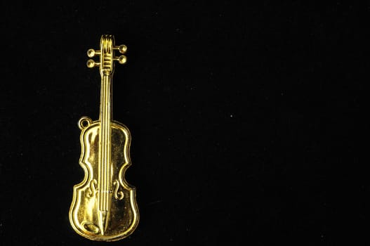 Gold Violin Instrument Figurine on a Colored Background
