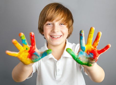 Smiling child showing his colored hands