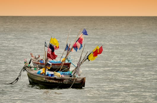Fishing boat in the sea at sunset sky
