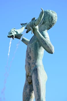 Statue of boy holding two fish