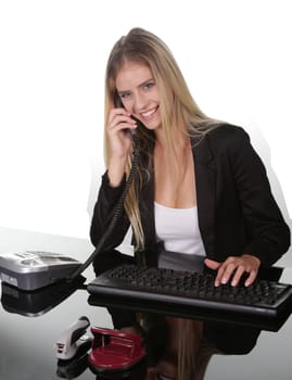 Lovely smiling business woman at her desk talking on the telephone