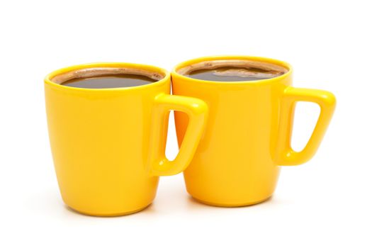 two yellow mugs of coffee on a white background