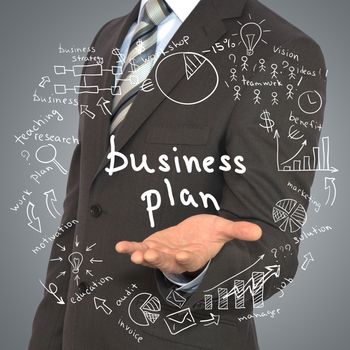 Man in suit holding business plan. Around fly business sketches