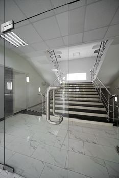 Glass doors with a kind on a marble staircase