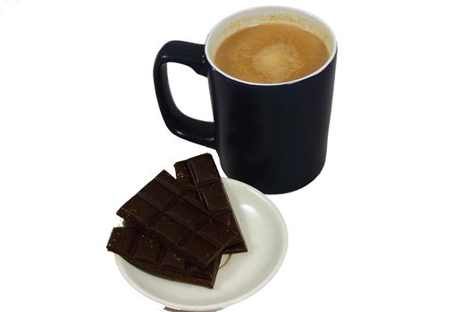 On a large white cup of coffee and a plate with slices of chocolate bar
