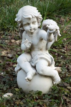 Small white angel statue on the cemetery ground