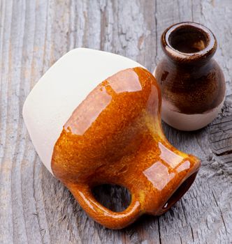 Little Handmade Earthenware Jugs closeup on Rustic Wooden background