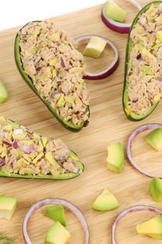 Avocado salad with tuna. Located on the wooden hardboard.